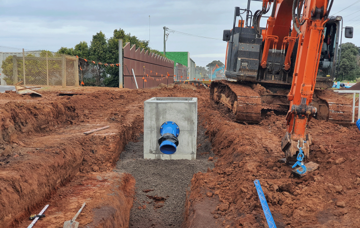 Excavator digging up dirt for a new customer outlet