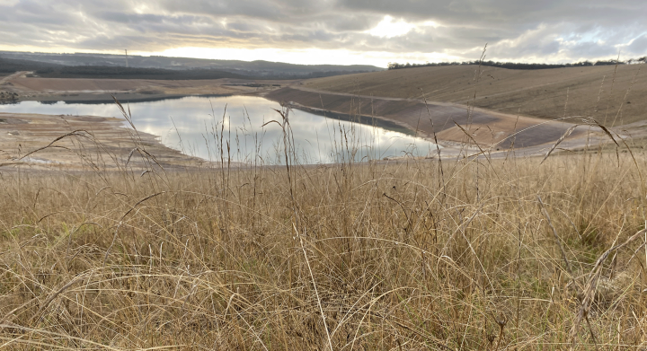 View of the mine pit across the completed grassland revegetation works