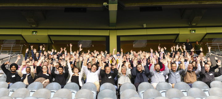 Group of smiling people with their hands up