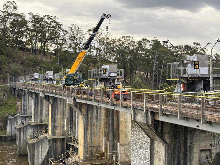 A crane and other machinery on a concrete bridge over water