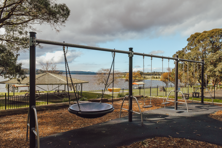 Swings on a playground looking over a lake