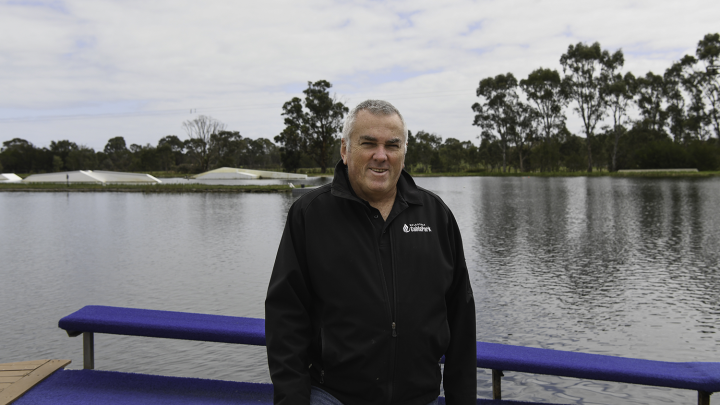 Smiling man standing in front of lake