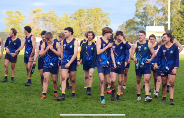 A group of football players in a blue uniform walking on a field