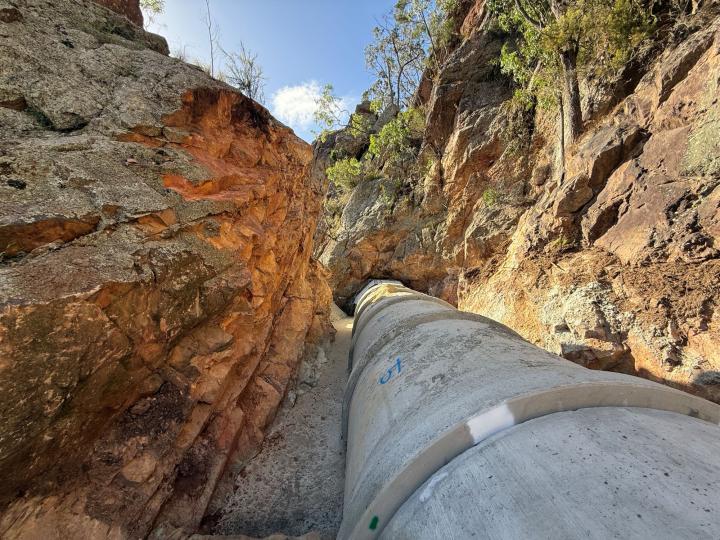 Pipe running through a gap in rock walls